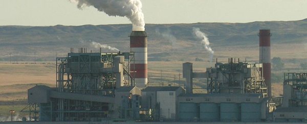 A large factory with colored smoke stacks